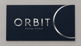 Silver foil typography and orbital line on a midnight navy business card